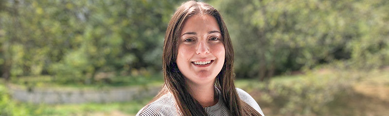 NJM employee Allison Brown posing in front of greenery.